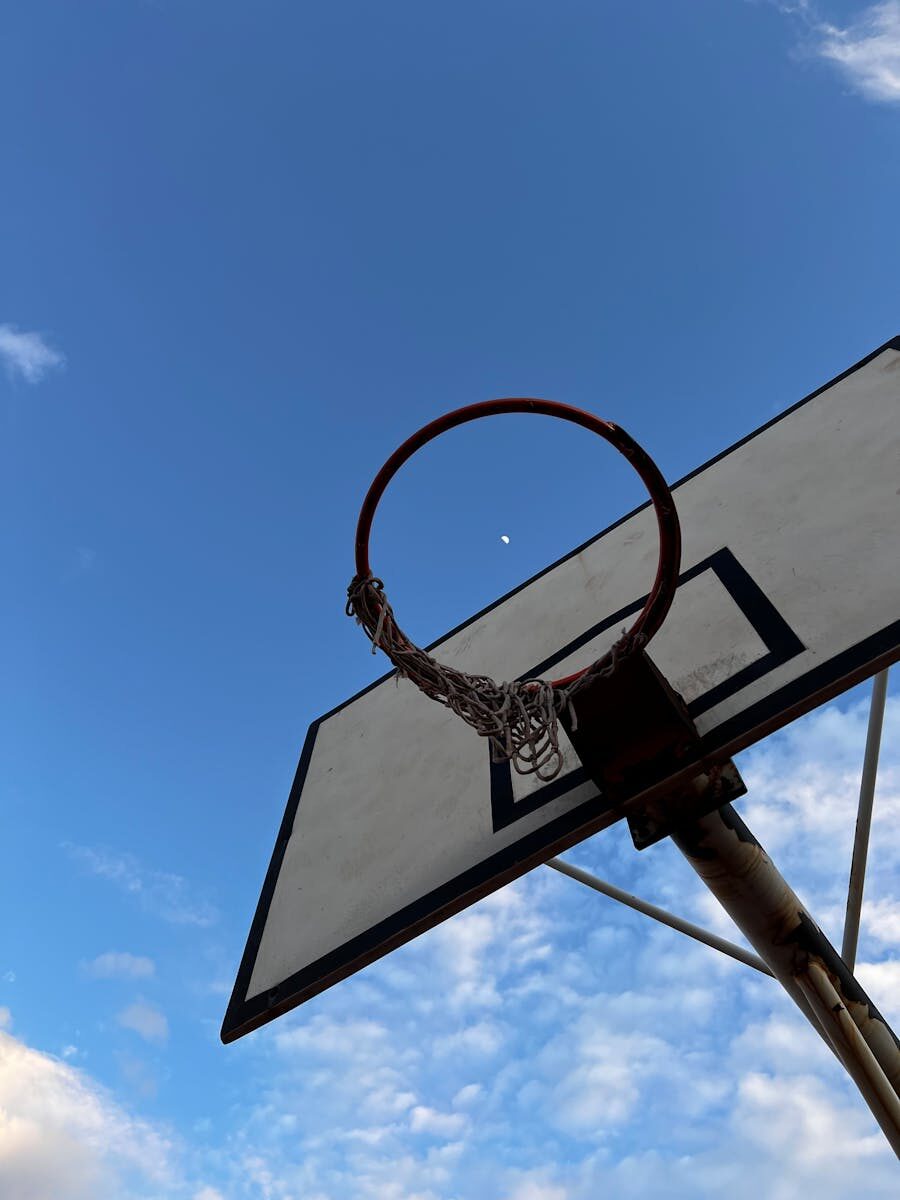 Basketball hoop silhouetted against a clear sky with the moon visible in Antalya, Türkiye.