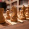 Focus on wooden chess pieces on a chessboard, creating a strategic atmosphere.