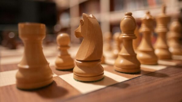 Focus on wooden chess pieces on a chessboard, creating a strategic atmosphere.