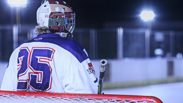 Exciting night roller hockey game in Tucson with player holding a stick.