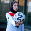 woman in white and blue long sleeve shirt holding white and black nike soccer ball