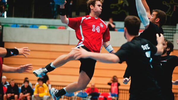 man holding ball while jumping near three mne