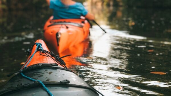 selective focus photography of woman riding kayak holding oar during daytime