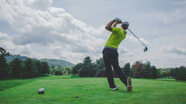 photo of man swinging golf driver