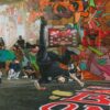 Dynamic breakdance competition in a graffiti-filled urban venue, capturing the energy and artistry of street dance culture.