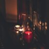 A close-up of candles illuminating a dark room with a warm, soft glow.
