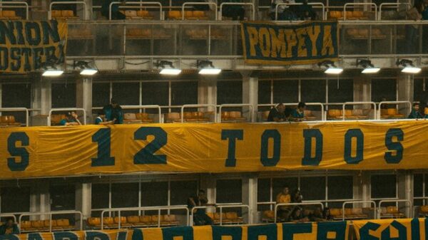 Vibrant atmosphere inside La Bombonera stadium, showcasing enthusiastic soccer fans and iconic banners.