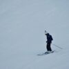 A skier navigating a snowy slope, showcasing winter sports and seasonal recreation.