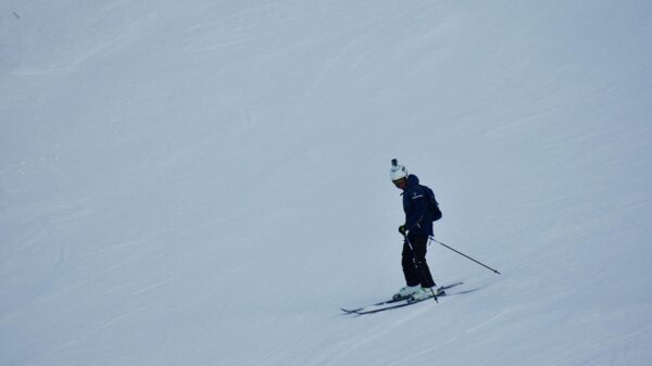 A skier navigating a snowy slope, showcasing winter sports and seasonal recreation.