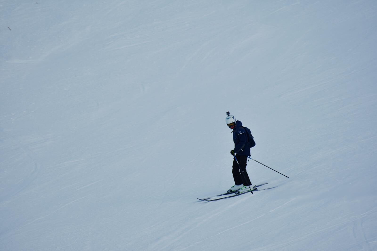 A skier navigating a snowy slope, showcasing winter sports and seasonal recreation.