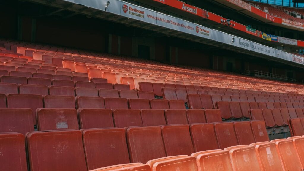 Close-up of empty seats at Emirates Stadium, capturing the iconic red seating of Arsenal's home ground.