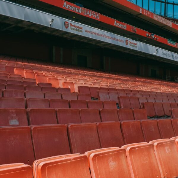 Close-up of empty seats at Emirates Stadium, capturing the iconic red seating of Arsenal's home ground.