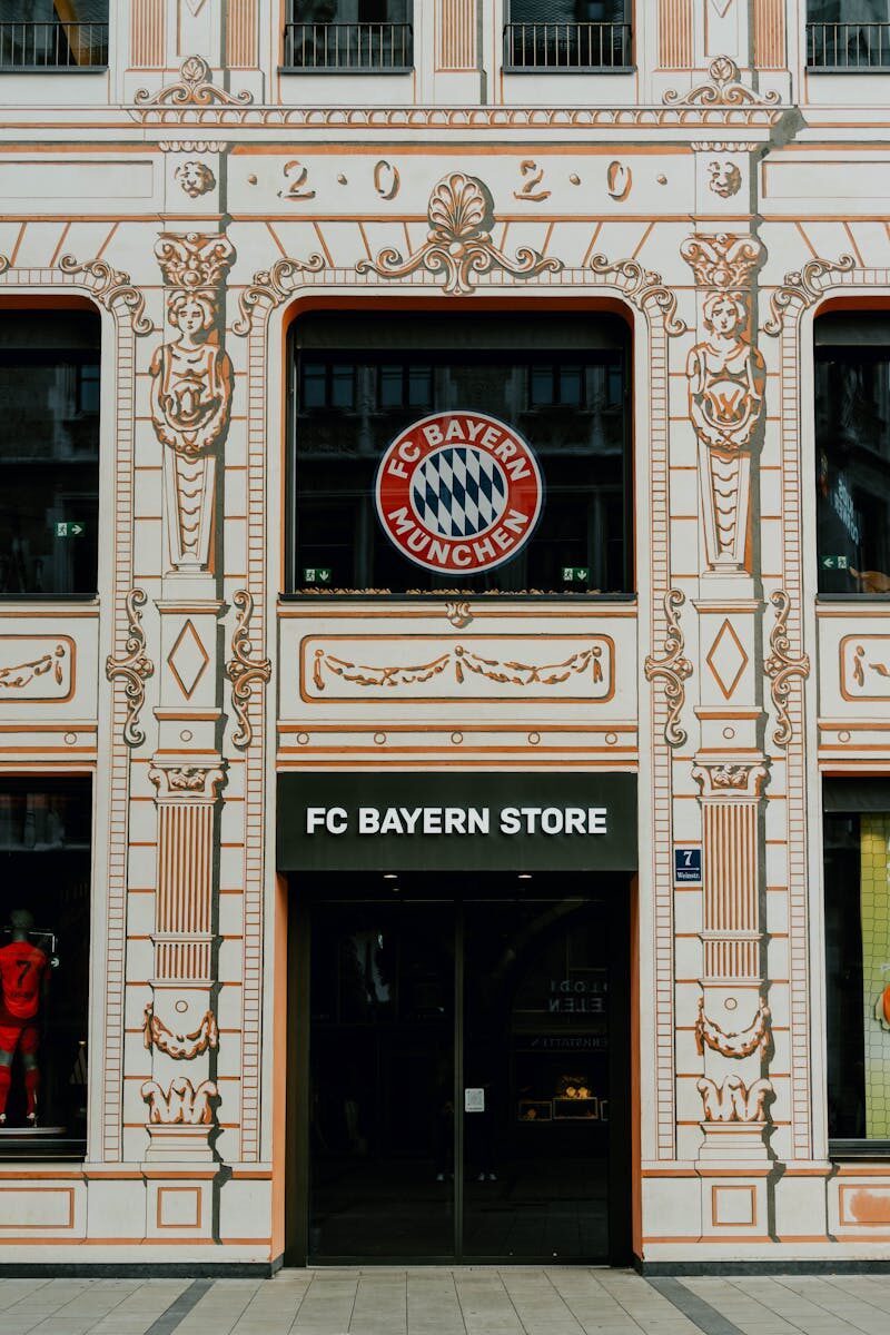 FC Bayern Store front in Munich showcasing the iconic Bayern Munich logo and architectural details.