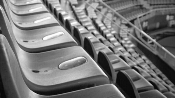 Black and white image of empty stadium seats with a focus on the symmetry and structure.