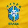 Close-up of the Brazilian football team emblem on a vibrant yellow jersey.