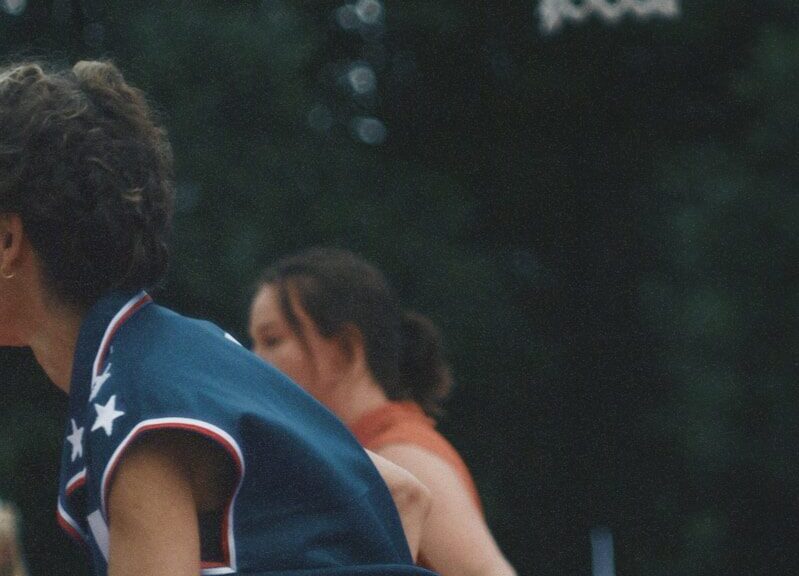 A man is playing basketball in front of a crowd