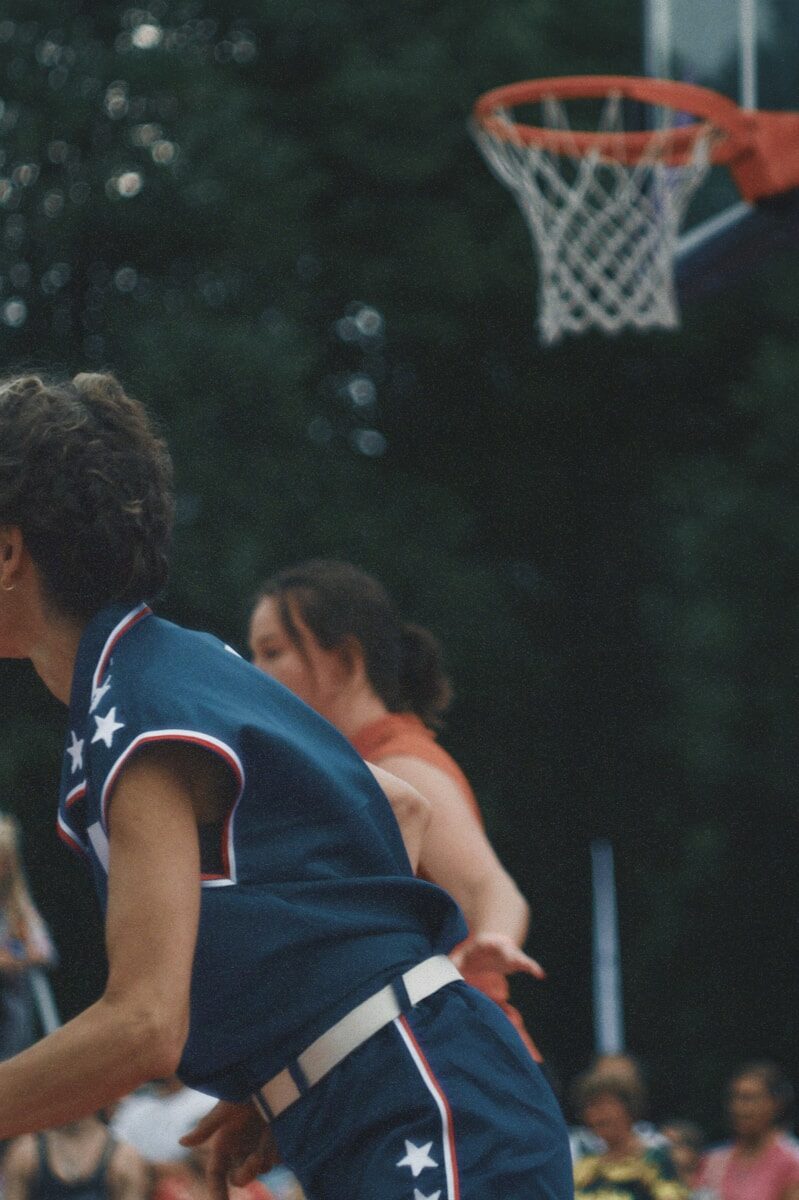 A man is playing basketball in front of a crowd