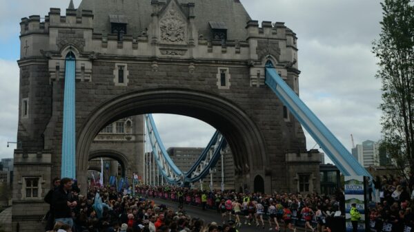 A crowd of people walking across a bridge