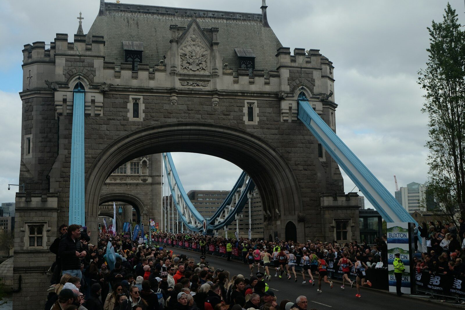 A crowd of people walking across a bridge