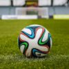 A vibrant adidas soccer ball on a green field, perfect for sports enthusiasts.