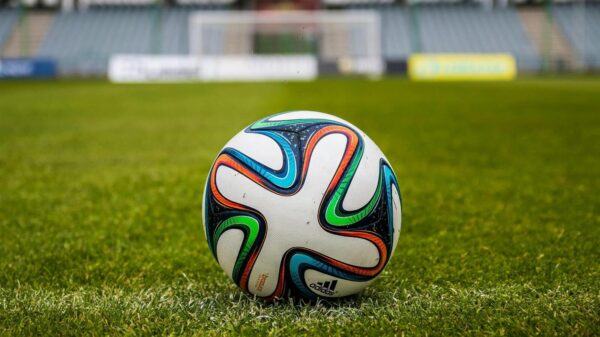 A vibrant adidas soccer ball on a green field, perfect for sports enthusiasts.