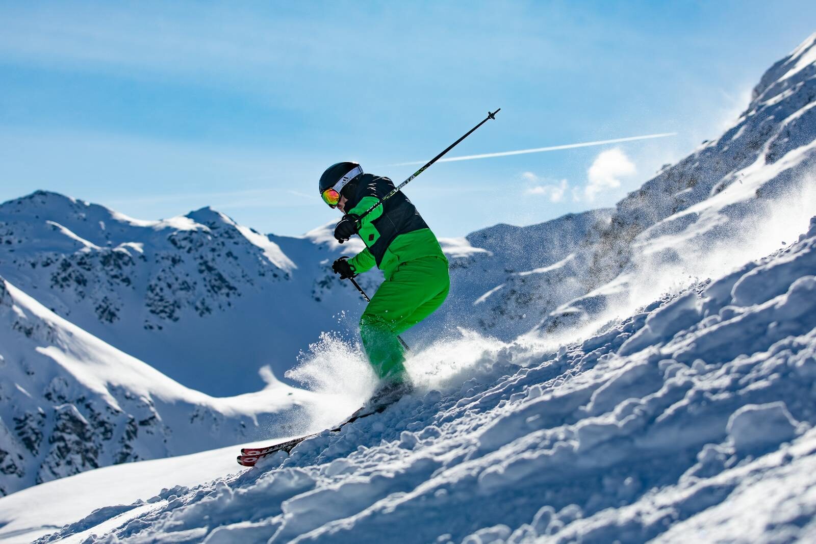 Skier in vibrant green outfit carving through snowy slopes in Vorarlberg, Austria.