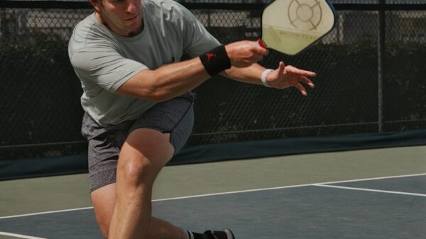 man in gray crew neck t-shirt and gray shorts sitting on basketball court