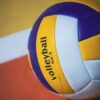 Colorful volleyball on an indoor court with visible lines, showcasing sports equipment.