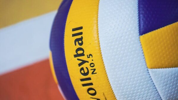 Colorful volleyball on an indoor court with visible lines, showcasing sports equipment.