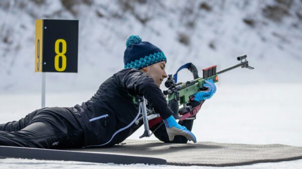 a person laying on a snow covered ground with a rifle