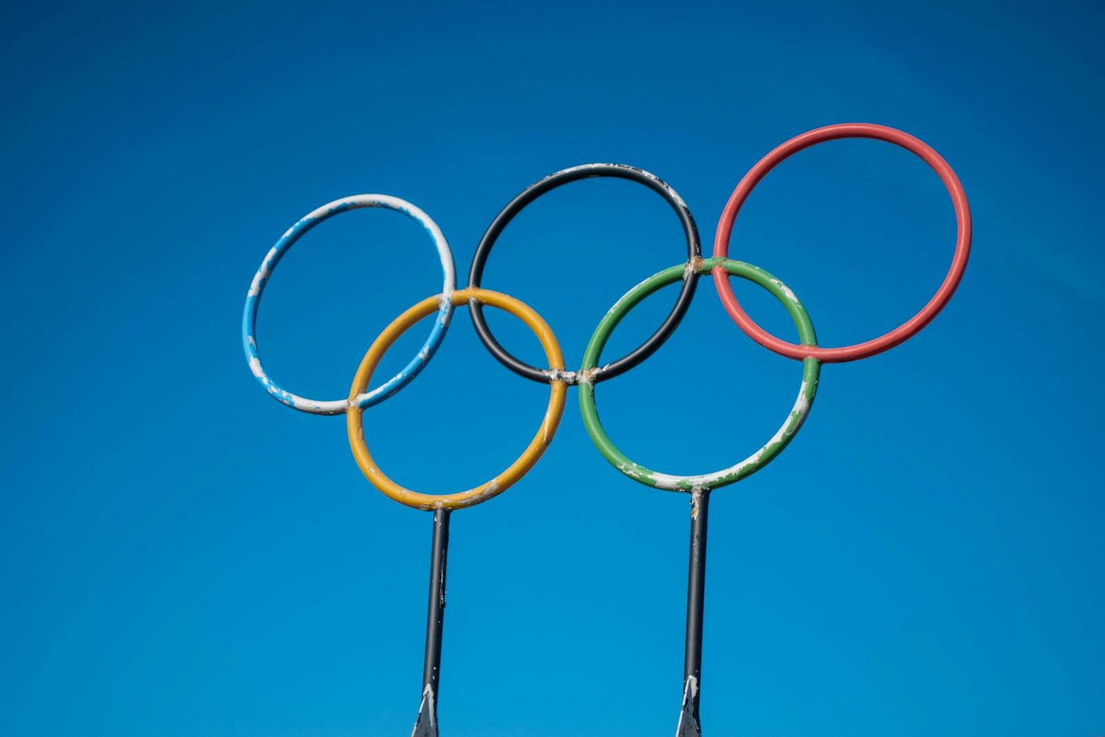 Olympic rings sculpture set against a clear blue sky in Lahti, Finland.