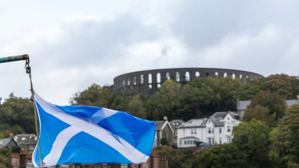 a scottish flag flying in front of a castle