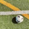 white and black soccer ball on green grass field
