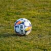 Close-up of a soccer ball on a grassy field under daylight. Perfect sports venue scene.