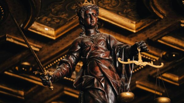 Detailed statue of Lady Justice holding scales and sword indoors with rich textures.