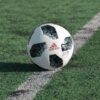 close-up photography of adidas soccer ball on field