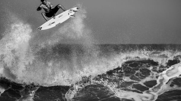 grayscale man surfing