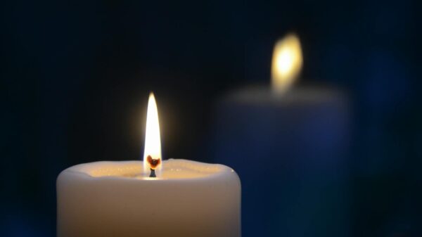 Close-up of a burning candle with a soft glow, creating a tranquil atmosphere.