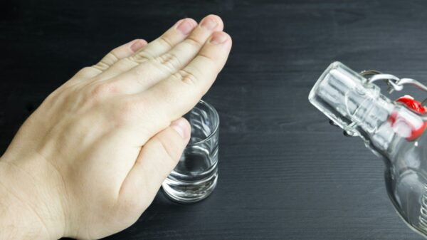 a hand reaching for a glass of water