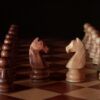 A close-up of wooden chess pieces on a chessboard, showcasing strategic depth and craftsmanship.