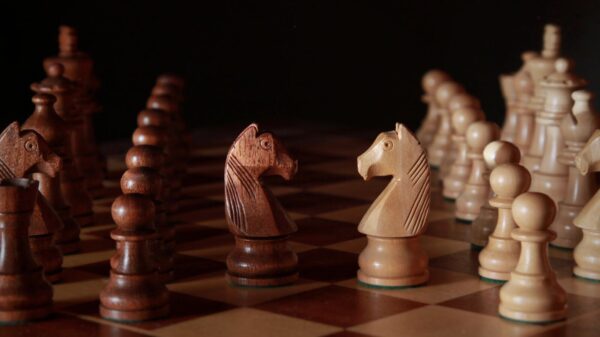 A close-up of wooden chess pieces on a chessboard, showcasing strategic depth and craftsmanship.