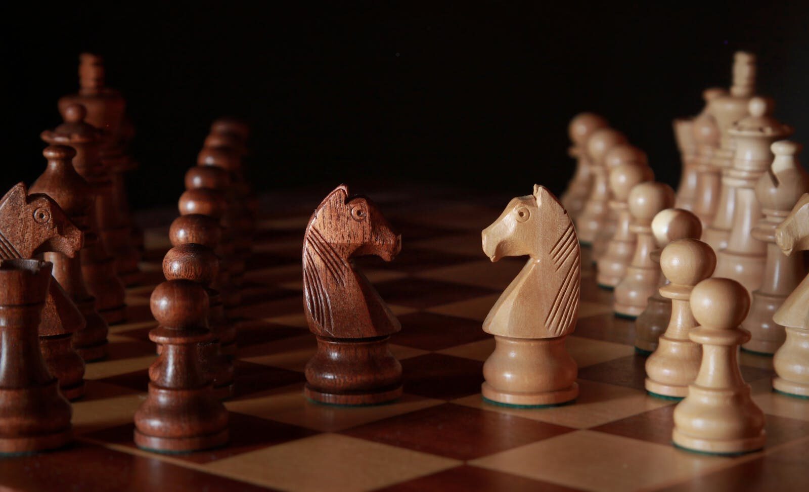 A close-up of wooden chess pieces on a chessboard, showcasing strategic depth and craftsmanship.