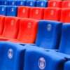 Rows of red and blue stadium seats featuring Paris emblems, vibrant and empty.