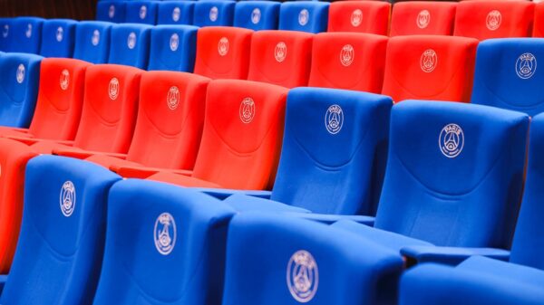 Rows of red and blue stadium seats featuring Paris emblems, vibrant and empty.