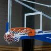Close-up of a basketball scoring through the hoop in an indoor court setting.