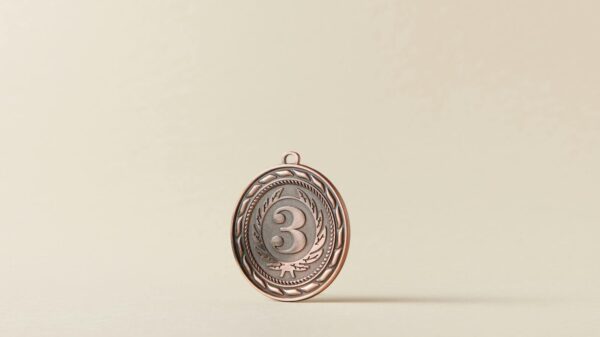 Close-up of a bronze medal with a number three on a plain white background.