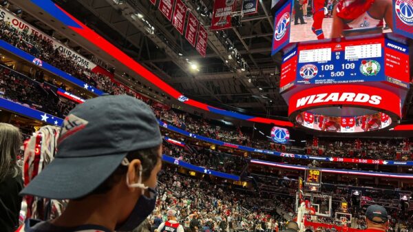 a crowd of people standing around a basketball court