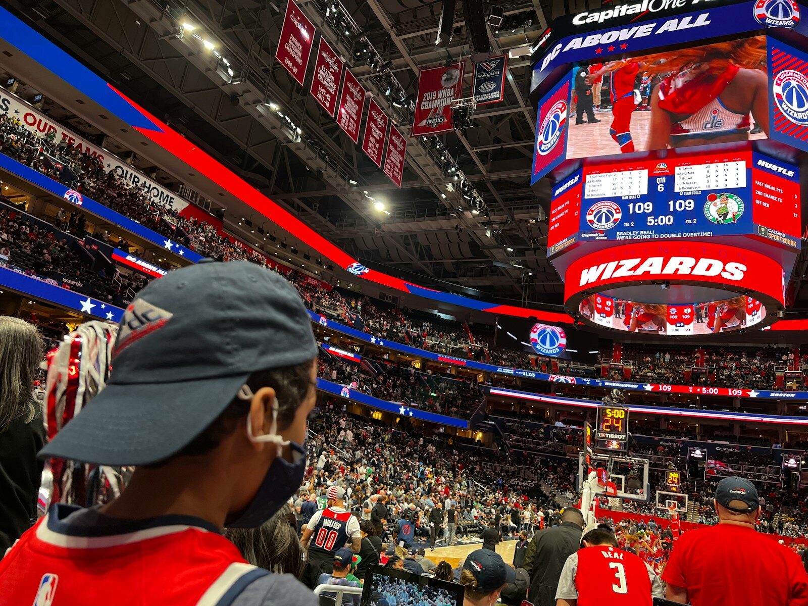 a crowd of people standing around a basketball court