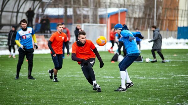 group of men playing soccer during daytime