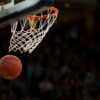 A basketball going through the hoop during a fast-paced game, capturing the excitement of the sport.